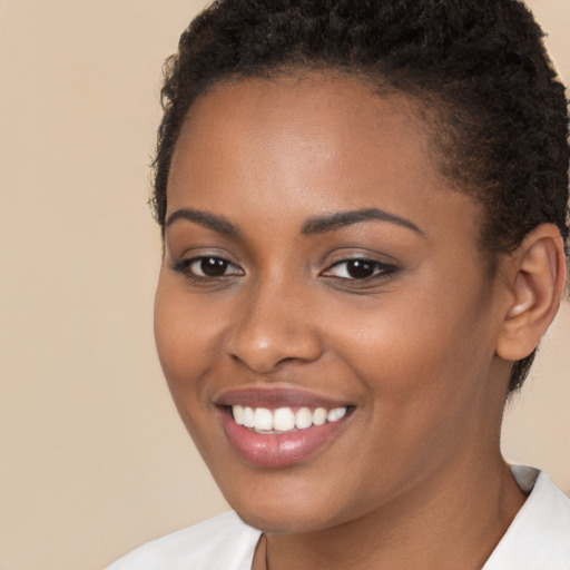 Joyful black young-adult female with short  brown hair and brown eyes