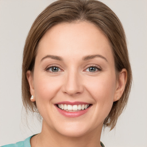 Joyful white young-adult female with medium  brown hair and green eyes