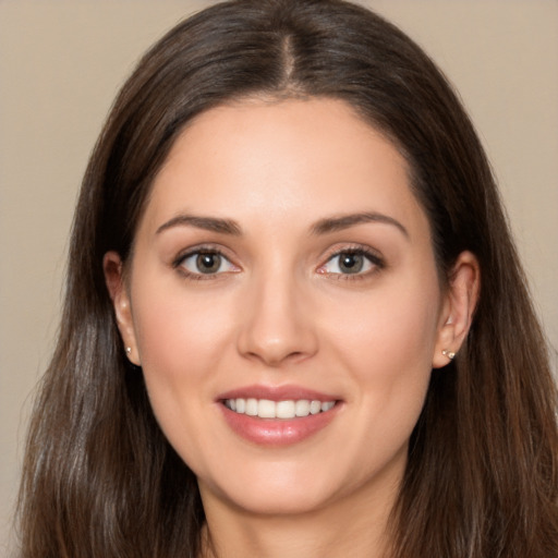 Joyful white young-adult female with long  brown hair and brown eyes