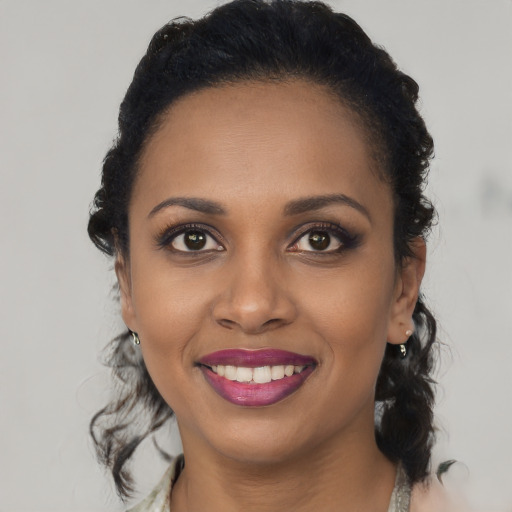 Joyful black young-adult female with medium  black hair and brown eyes