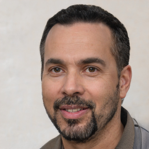 Joyful white adult male with short  black hair and brown eyes