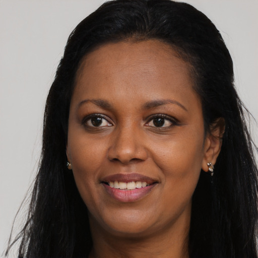 Joyful black young-adult female with long  brown hair and brown eyes