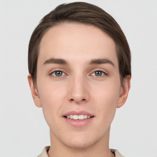 Joyful white young-adult male with short  brown hair and grey eyes