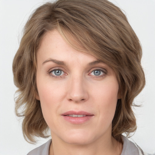 Joyful white young-adult female with medium  brown hair and blue eyes