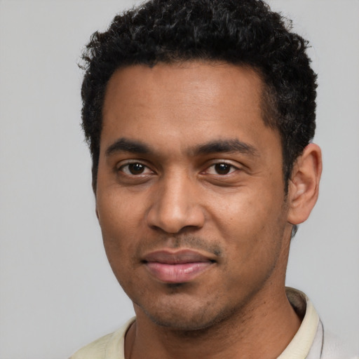 Joyful black young-adult male with short  black hair and brown eyes