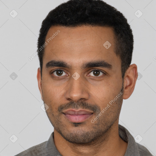 Joyful black young-adult male with short  black hair and brown eyes