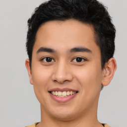 Joyful latino young-adult male with short  brown hair and brown eyes