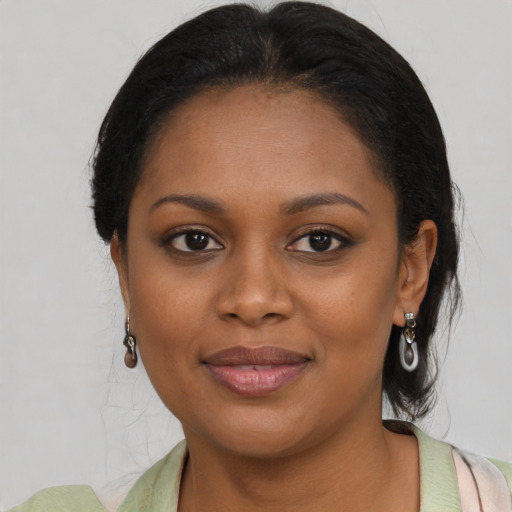 Joyful black young-adult female with medium  brown hair and brown eyes