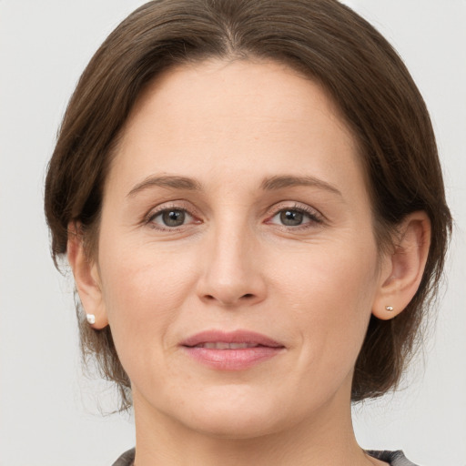 Joyful white adult female with medium  brown hair and grey eyes