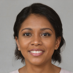 Joyful black young-adult female with medium  brown hair and brown eyes