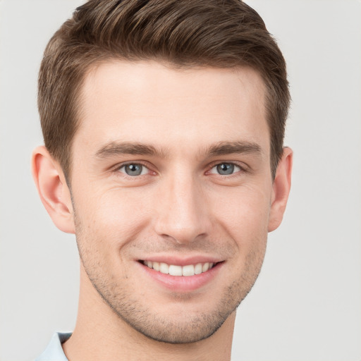 Joyful white young-adult male with short  brown hair and grey eyes