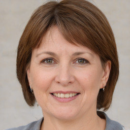 Joyful white adult female with medium  brown hair and grey eyes