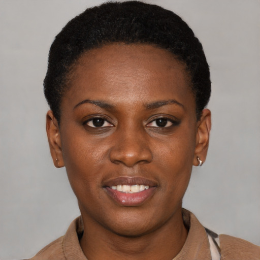 Joyful black young-adult female with short  black hair and brown eyes