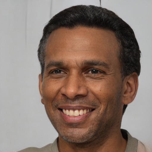 Joyful latino adult male with short  black hair and brown eyes