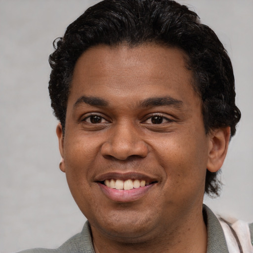 Joyful latino young-adult male with short  black hair and brown eyes