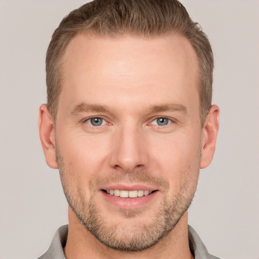 Joyful white adult male with short  brown hair and grey eyes