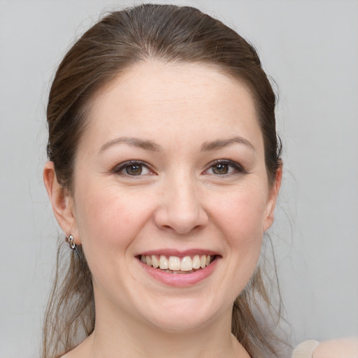 Joyful white young-adult female with medium  brown hair and grey eyes