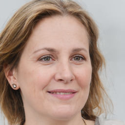 Joyful white adult female with medium  brown hair and blue eyes