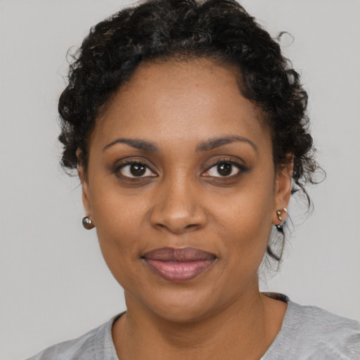 Joyful black young-adult female with short  black hair and brown eyes