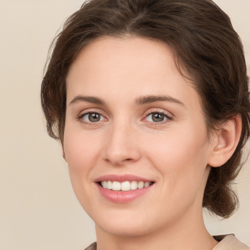 Joyful white young-adult female with medium  brown hair and green eyes