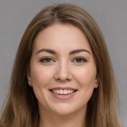 Joyful white young-adult female with long  brown hair and brown eyes