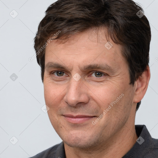 Joyful white adult male with short  brown hair and brown eyes