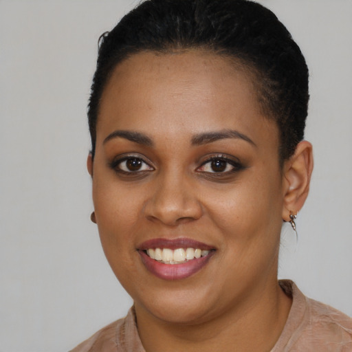 Joyful black young-adult female with short  black hair and brown eyes