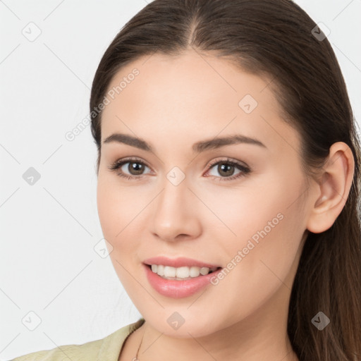 Joyful white young-adult female with long  brown hair and brown eyes