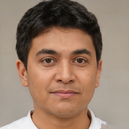 Joyful latino young-adult male with short  brown hair and brown eyes