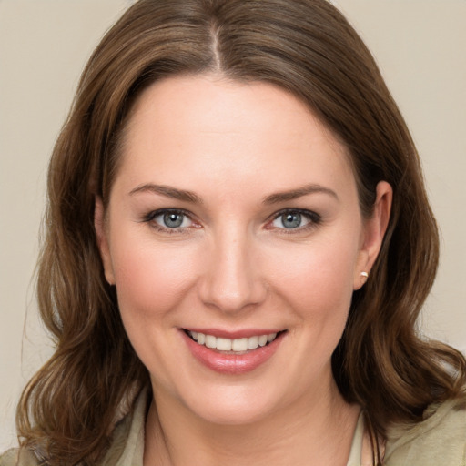 Joyful white young-adult female with medium  brown hair and grey eyes