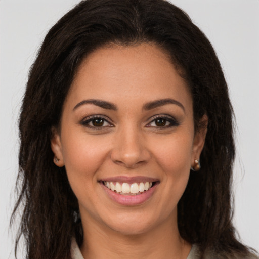 Joyful latino young-adult female with long  brown hair and brown eyes