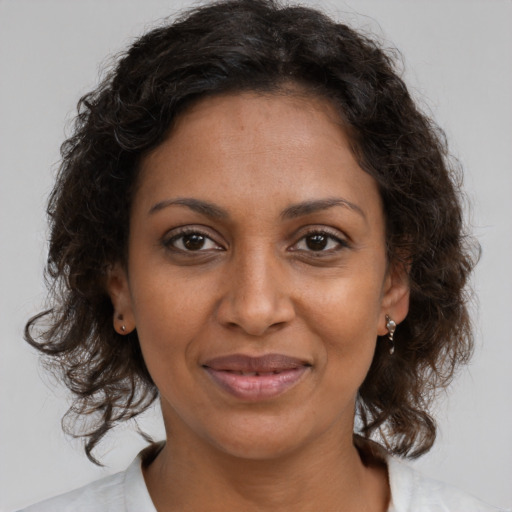 Joyful black adult female with medium  brown hair and brown eyes