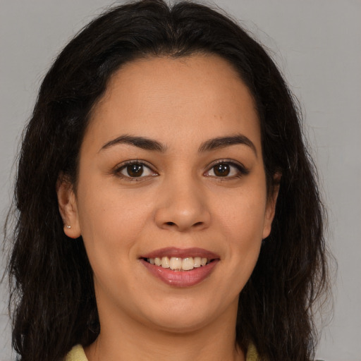 Joyful latino young-adult female with long  brown hair and brown eyes