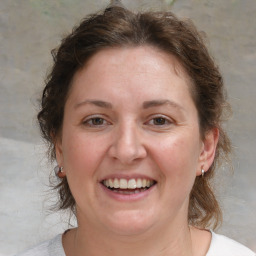 Joyful white young-adult female with medium  brown hair and blue eyes