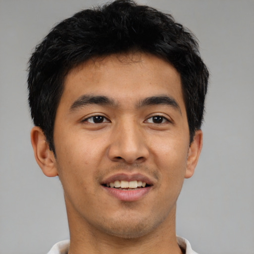 Joyful latino young-adult male with short  brown hair and brown eyes