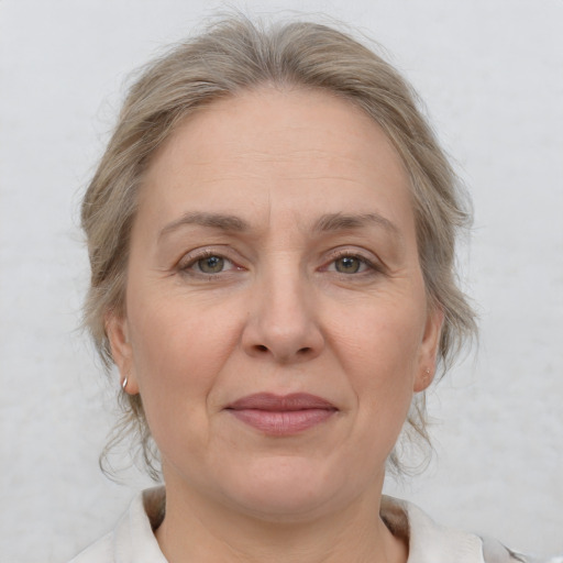 Joyful white adult female with medium  brown hair and grey eyes