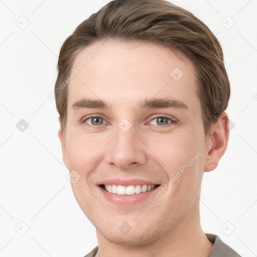 Joyful white young-adult male with short  brown hair and grey eyes