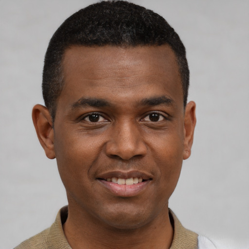 Joyful black young-adult male with short  black hair and brown eyes