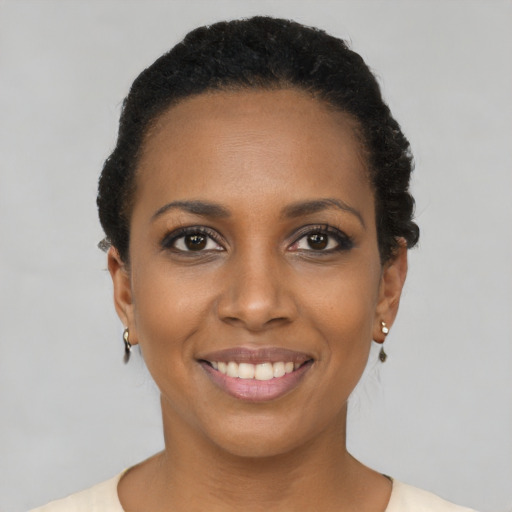 Joyful black young-adult female with short  black hair and brown eyes