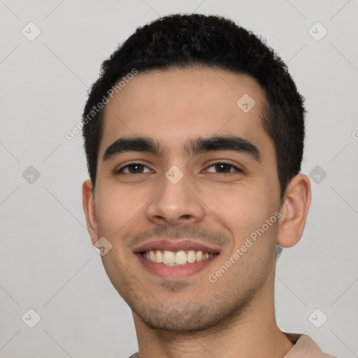 Joyful latino young-adult male with short  black hair and brown eyes