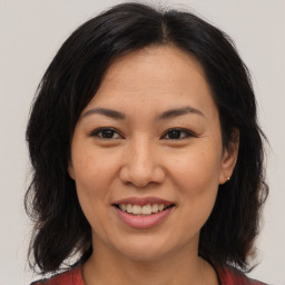 Joyful asian adult female with medium  brown hair and brown eyes