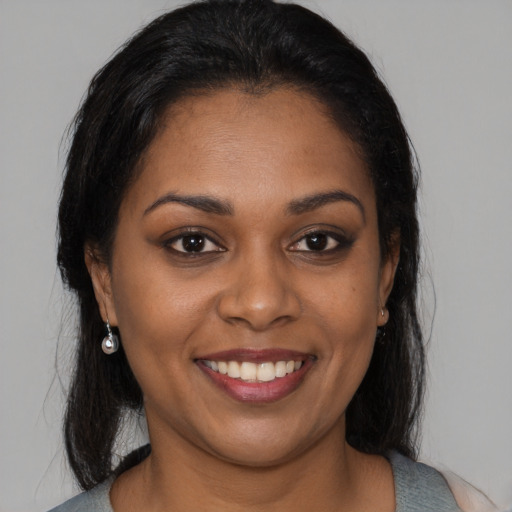 Joyful black young-adult female with medium  brown hair and brown eyes