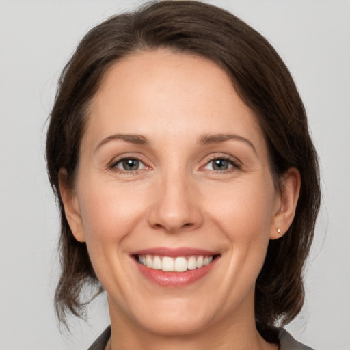 Joyful white adult female with medium  brown hair and brown eyes