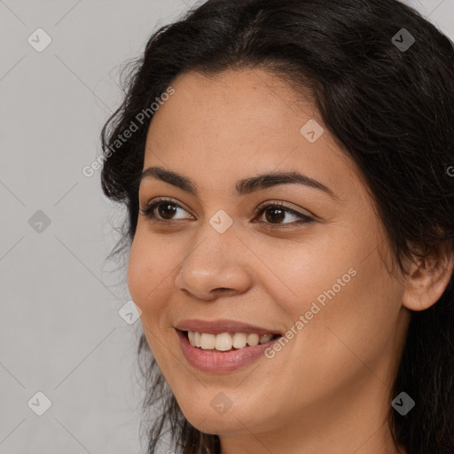 Joyful latino young-adult female with long  brown hair and brown eyes