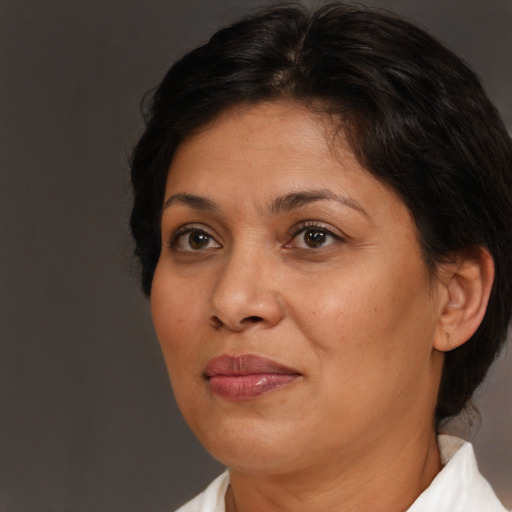 Joyful latino adult female with medium  brown hair and brown eyes