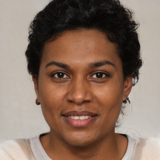 Joyful black young-adult female with short  brown hair and brown eyes