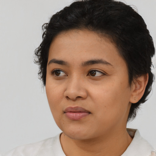 Joyful latino young-adult female with short  black hair and brown eyes