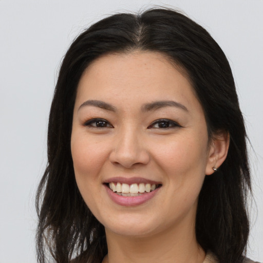 Joyful asian young-adult female with long  brown hair and brown eyes