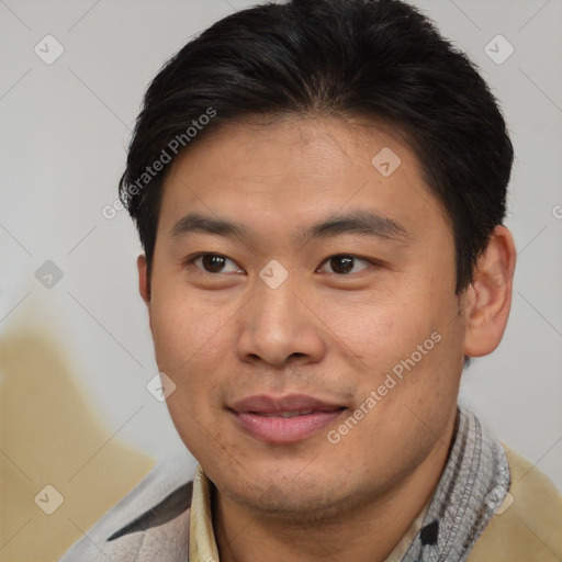 Joyful asian young-adult male with short  brown hair and brown eyes