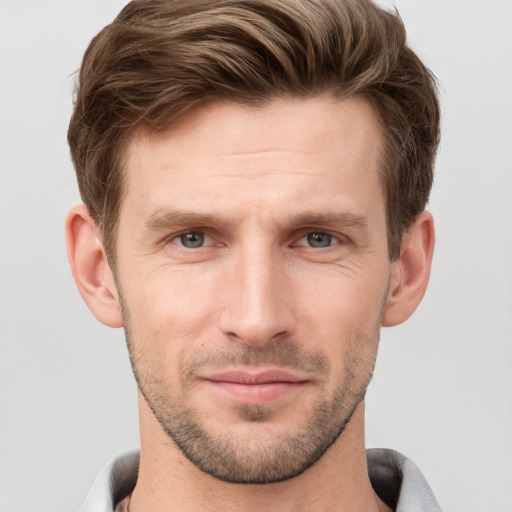 Joyful white young-adult male with short  brown hair and grey eyes